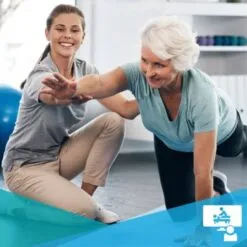 Clinician helps elderly patient with an exercise on the floor