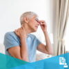 Eldery woman grimacing holding her neck and touching her face