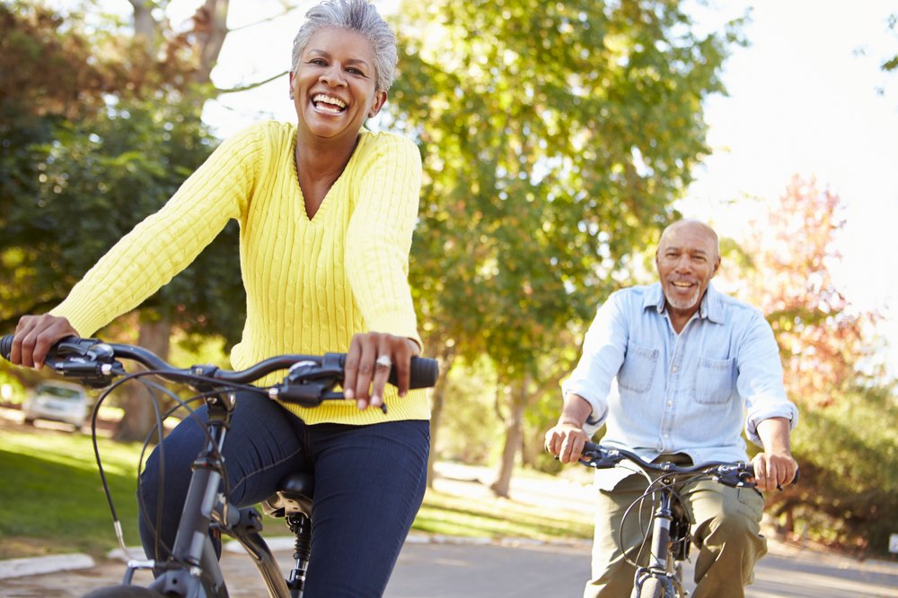 Two middle aged adults cycling outdoors