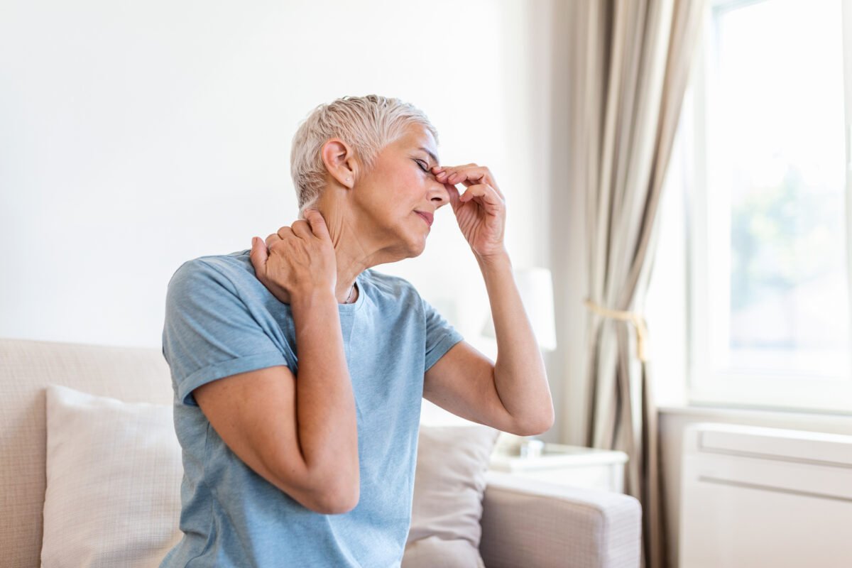 Woman suffering from stress or a headache grimacing in pain.