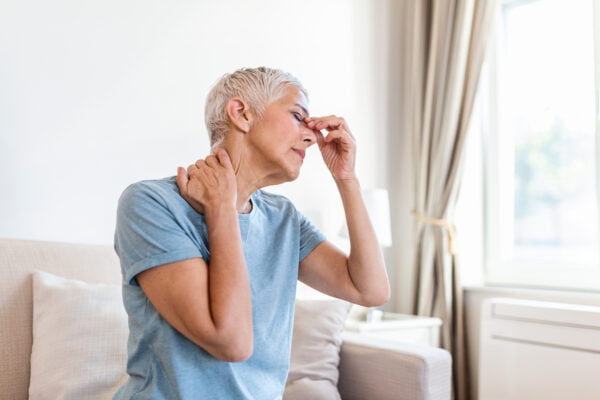 Woman suffering from stress or a headache grimacing in pain.