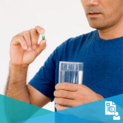 Man holding a glass of water and a single pill