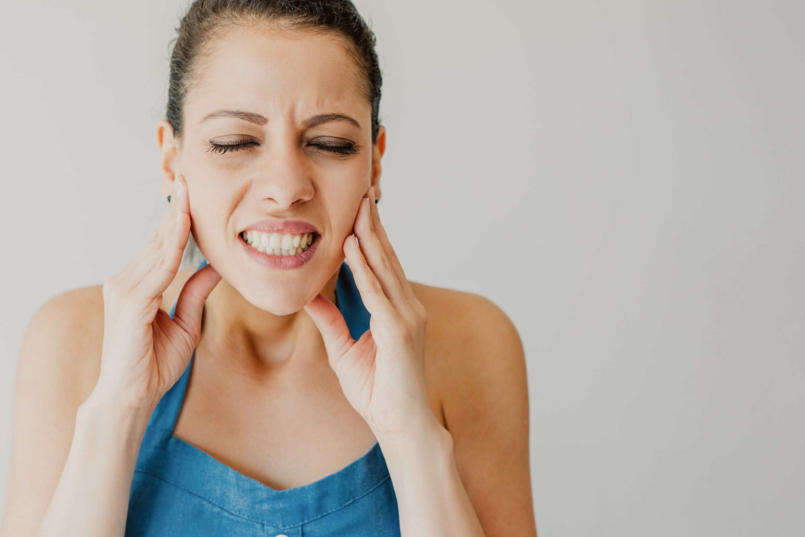 Annoyed young woman suffering from jaw pain