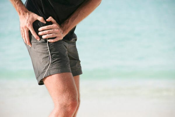 A man holding his painful right hip
