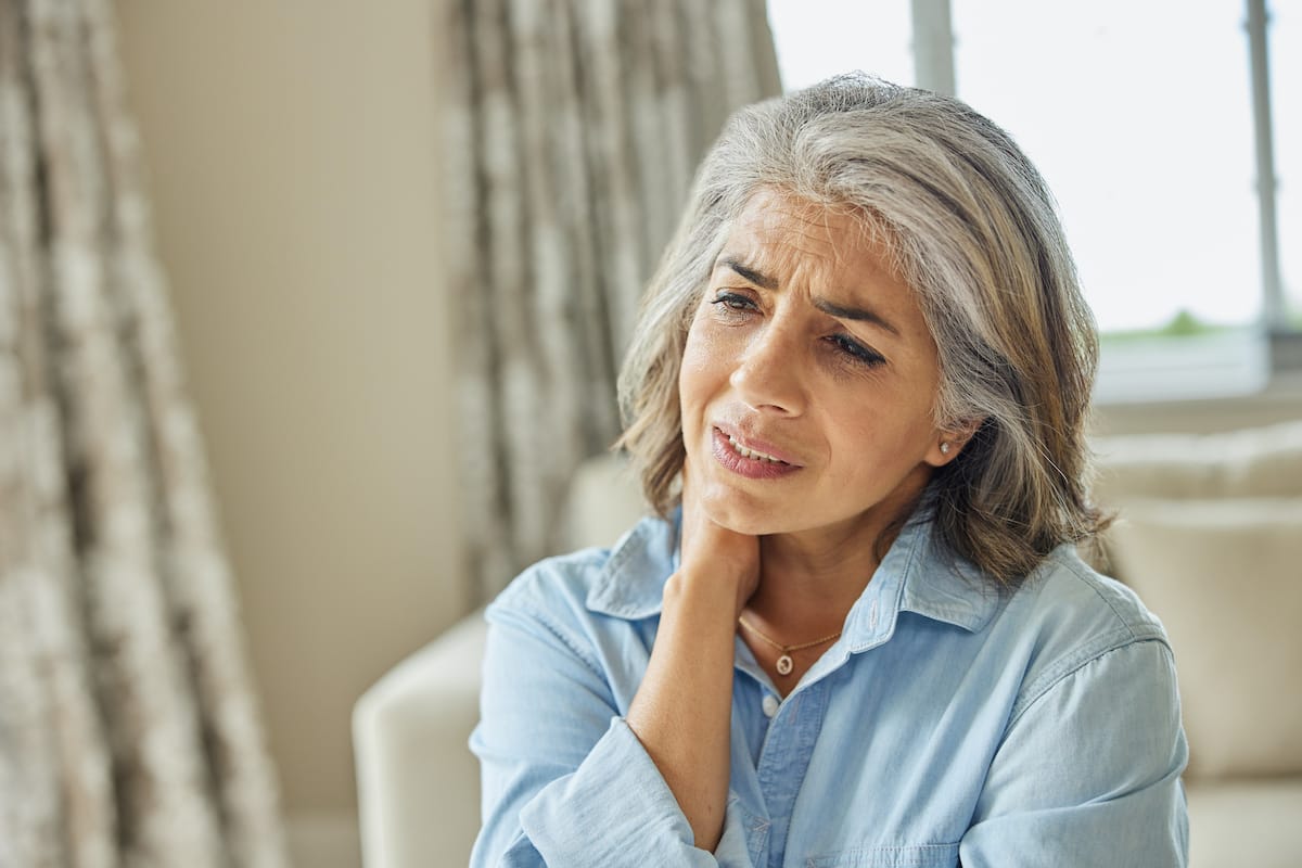 Mature woman at home with neck pain