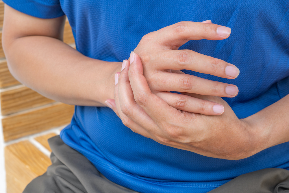 Thumb and finger injuries - young patient holding a painful hand